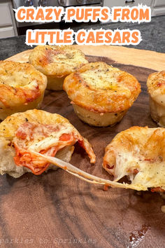 several mini pizzas sitting on top of a cutting board with the words crazy puffs from little caesars