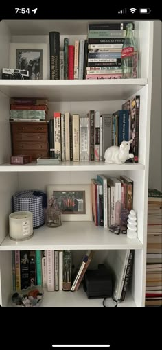 a white book shelf filled with lots of books