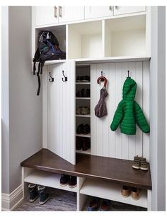 a coat rack with shoes and umbrellas hanging on the hooks in front of it