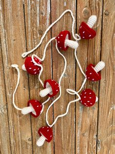 red and white crocheted christmas lights hanging on wooden planked wall with string