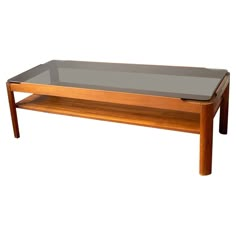 a coffee table with glass top and wooden frame on the bottom, against a white background