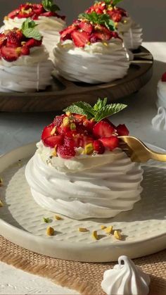 two desserts with strawberries and whipped cream on top are sitting on serving platters