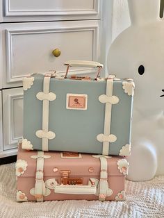 two suitcases are stacked on top of each other in front of a white bunny