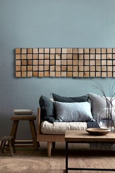 a living room with blue walls and wooden squares hanging on the wall above the couch