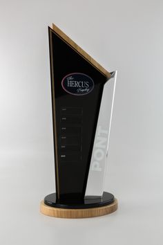 a black and gold trophy with the word hero's on it, sitting on top of a wooden base