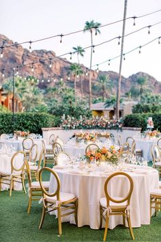 an outdoor dining area with tables and chairs set up for a formal function in front of palm trees