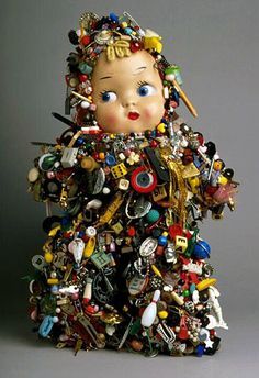 a doll made out of many different types of buttons and magnets on it's body