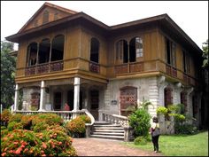 a person standing in front of a large house with lots of windows and balconies