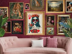 a pink couch sitting in front of a wall filled with pictures and paintings on it