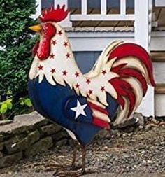 a statue of a rooster standing in front of a house