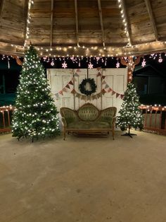 a living room decorated for christmas with lights on the ceiling and trees in the background