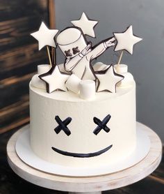 a white cake decorated with stars and an astronaut on top