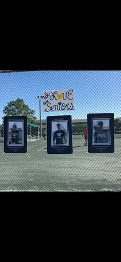 four framed pictures are hanging on a fence