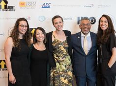 four women and one man are posing for a photo on the red carpet at an event