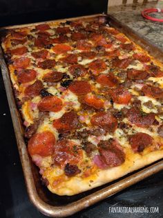 a pizza sitting on top of a pan covered in cheese and pepperoni toppings