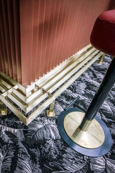 a red chair sitting on top of a wooden floor next to a tall metal pole