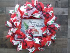 a red and white christmas wreath hanging on a wooden wall