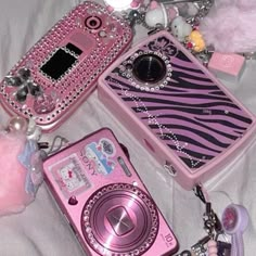 several different types of cell phones are laying on a white sheet with beads and charms