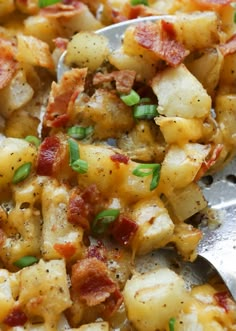 a close up of a spoon with some food on it and potatoes in the background