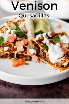 two quesadillas on a white plate topped with sour cream and cilantro