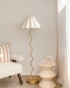 a floor lamp sitting next to a white chair