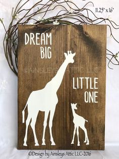 a wooden sign that says dream big and a giraffe