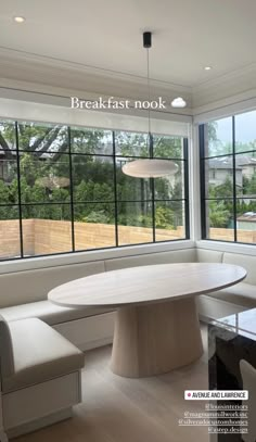 a table and bench in front of large windows