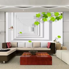 a living room with white walls and green leaves on the ceiling, along with couches