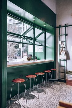 a row of stools sitting in front of a window next to a counter top