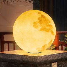 a large yellow moon lamp sitting on top of a table