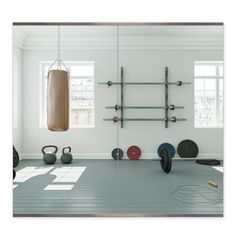 an empty gym room with exercise equipment in the foreground and a punching bag on the wall