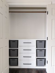 an organized closet with white drawers and black baskets