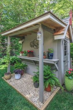 a garden shed with potted plants on the side and a butterfly flying above it