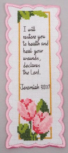 a pink and white cross stitched card with a verse on the front saying i will restore your health and heal your bodies, because the lord