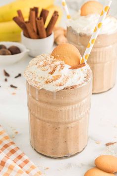 two desserts with whipped cream and cookies in the background