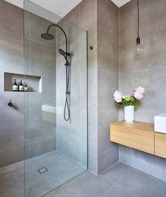 a bathroom with a sink, mirror and shower in it's center wall is shown