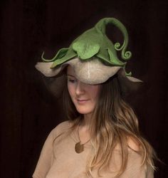 a woman wearing a green hat with an octopus on it's top and long hair