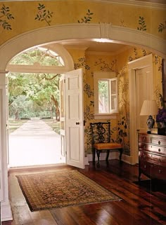 an archway leading into a room with a rug on the floor and a table in front of it