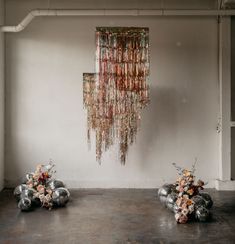 two vases filled with flowers sitting on top of a floor next to a chandelier