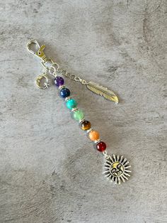 a keychain with an arrow and seven chakras on the front, surrounded by multicolored beads