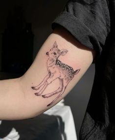 a small deer tattoo on the arm