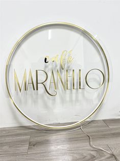 a glass sign that says cafe marmelo in gold lettering on a white wall