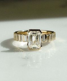 an emerald cut diamond ring with baguettes on the sides