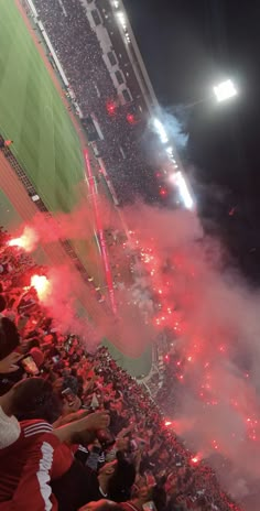 a stadium filled with lots of people watching fireworks