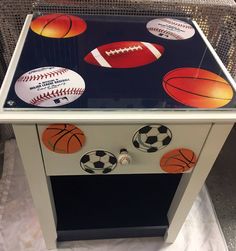 a small cabinet with sports themed knobs on the front and sides, along with balls painted on it