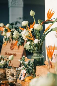 there are many flowers in the vases on the table with other things around them