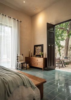 a bedroom with a bed, dresser and sliding glass doors leading to an outside patio