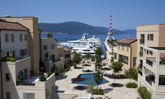 an aerial view of several boats docked in the water near some buildings and yachts