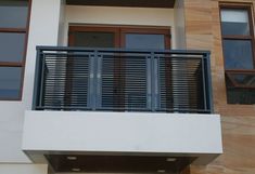 an apartment building with two balconies and wooden shutters on the balcony area