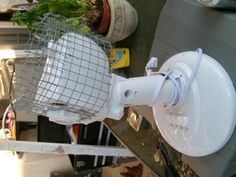 a white toilet sitting on top of a metal rack next to a planter filled with flowers